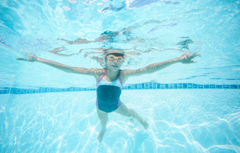 joyful girl swimming underwater in pool