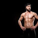 muscular swimmer standing in swimming cap and swim goggles isola