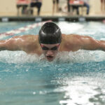 Young male swimmer swims the butterfly during a competition
